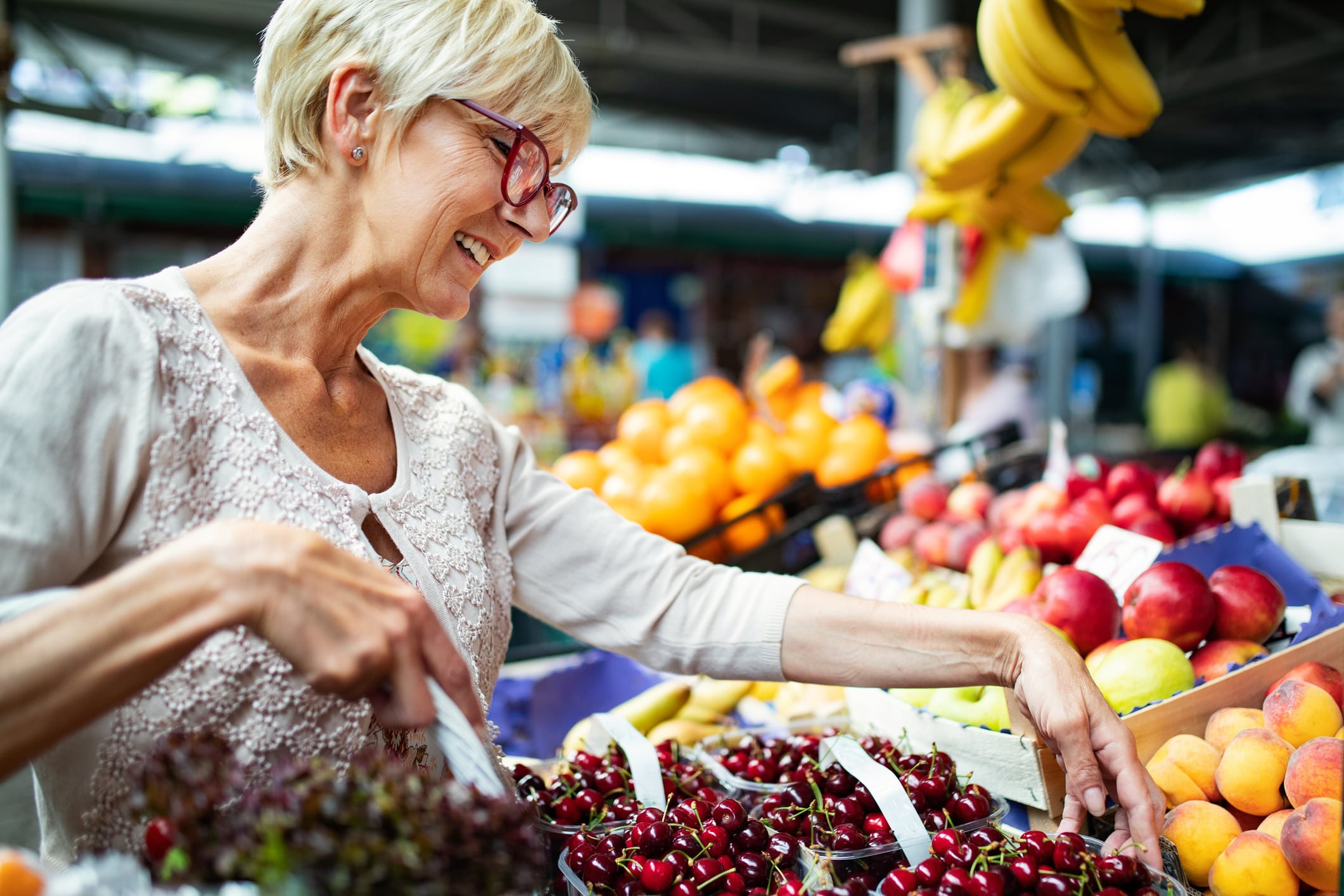 Older shopper comparing grocery prices while shopping on a fixed budget