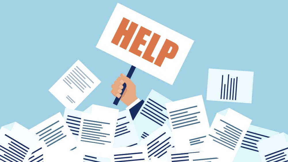 A "HELP" sign being held up from under a mountain of bills.