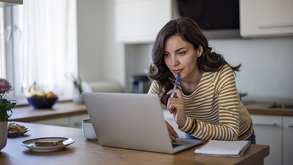 A woman researching debt settlement on her laptop.