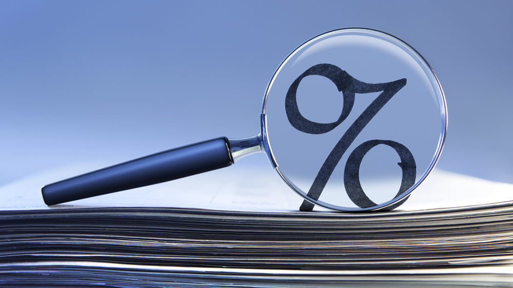 A magnifying glass over the interest rate percentage symbol.