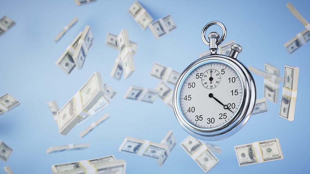 A stopwatch with money around it.