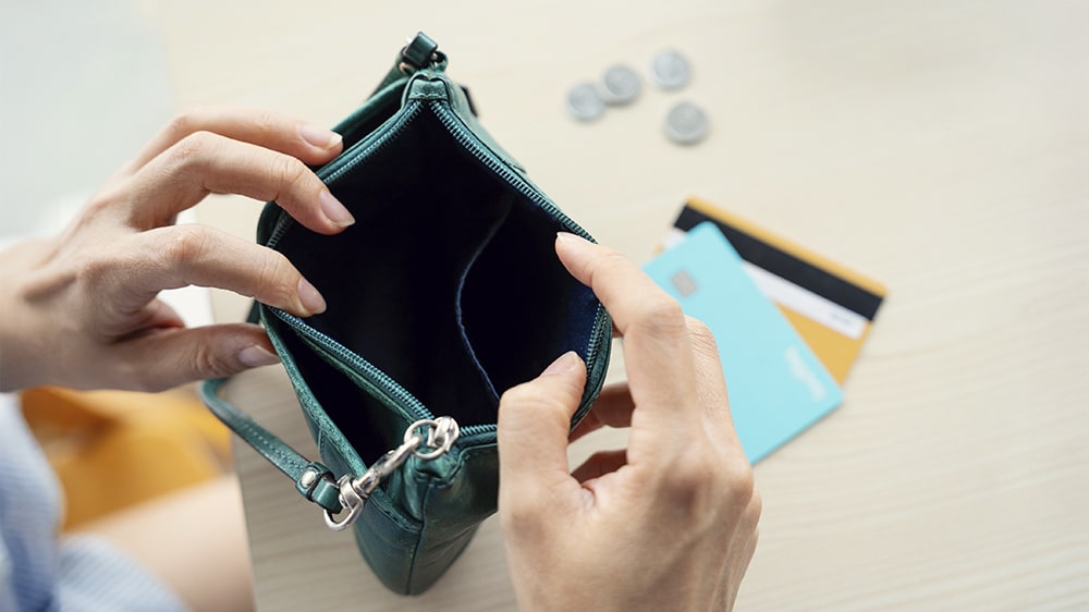 A person looking through an empty wallet.