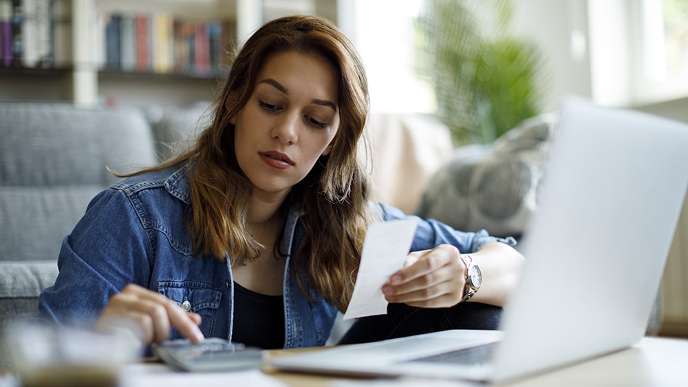 Person reviewing a monthly budget and loan statements at a desk
