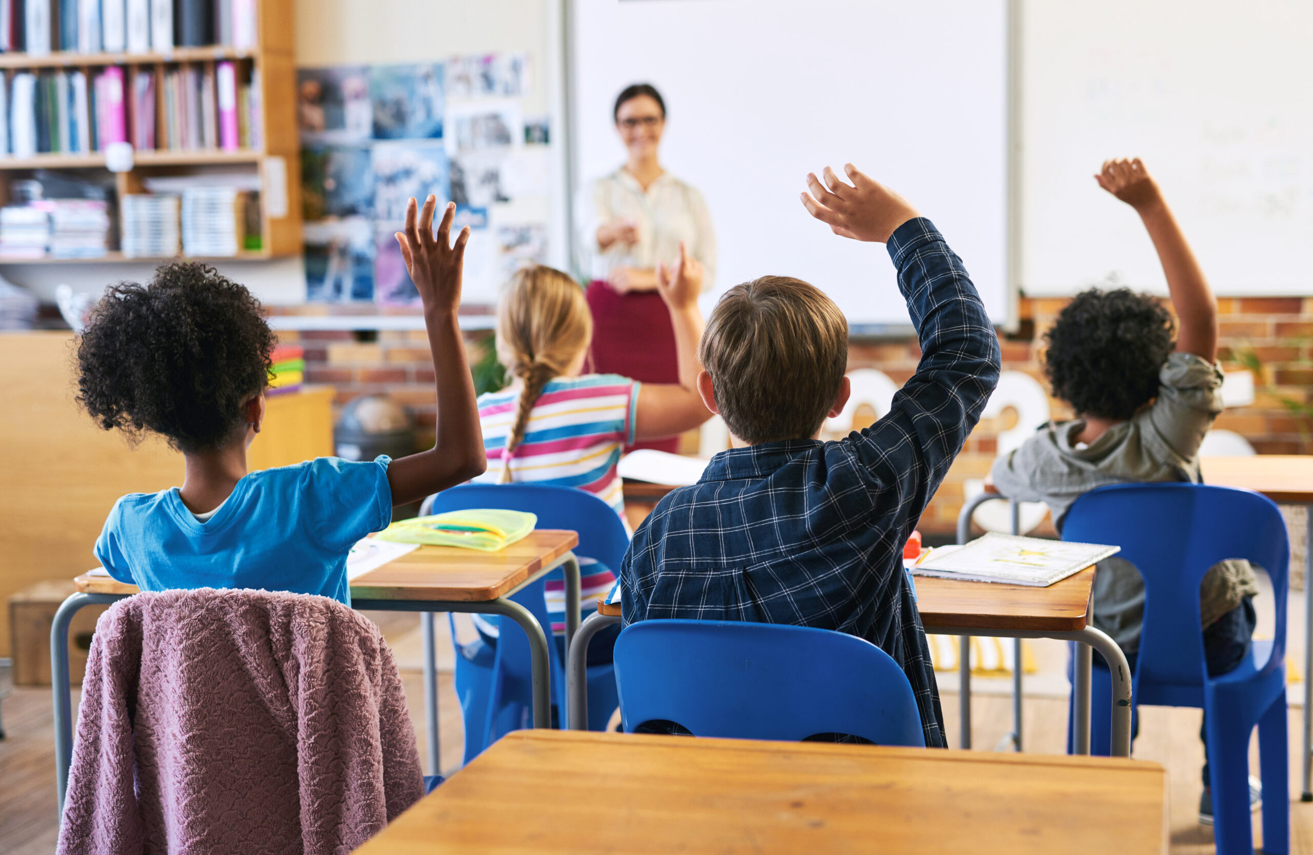A teacher working at a desk in a classroom